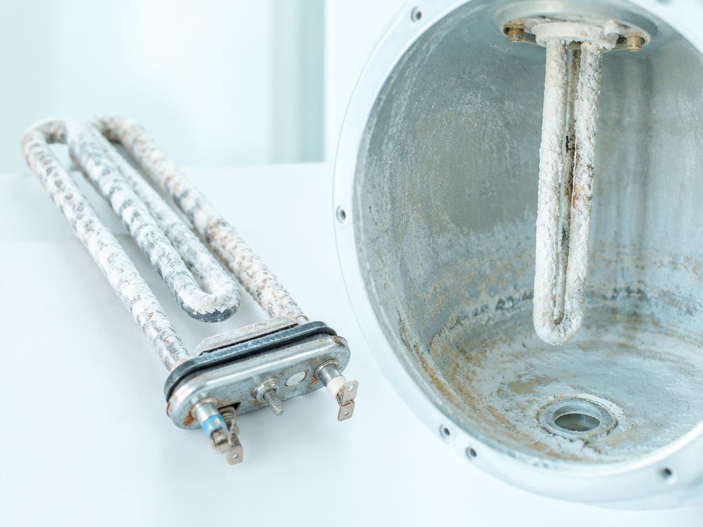 Résistance et cuve couvertes de tartre dans un chauffe-eau